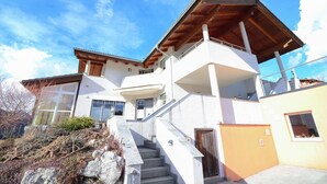 A two-story house with a staircase leading to a balcony. - Ferienwohnung in Abtenau (Abtenau)
