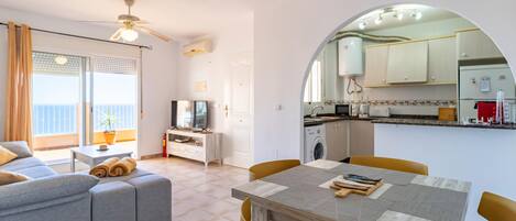 A modern apartment with a dining area, kitchen, and living room.