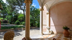 Ein Innenhof mit Säulen, einem Brunnen und einer Statue.