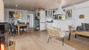 A modern kitchen with white cabinets, a large island, and a hanging light fixture.