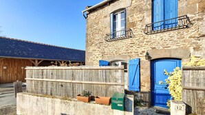 A stone building with a wooden fence, a blue door, and a blue window with shutters. - 2 bedroom beautiful home in Taden (Taden)