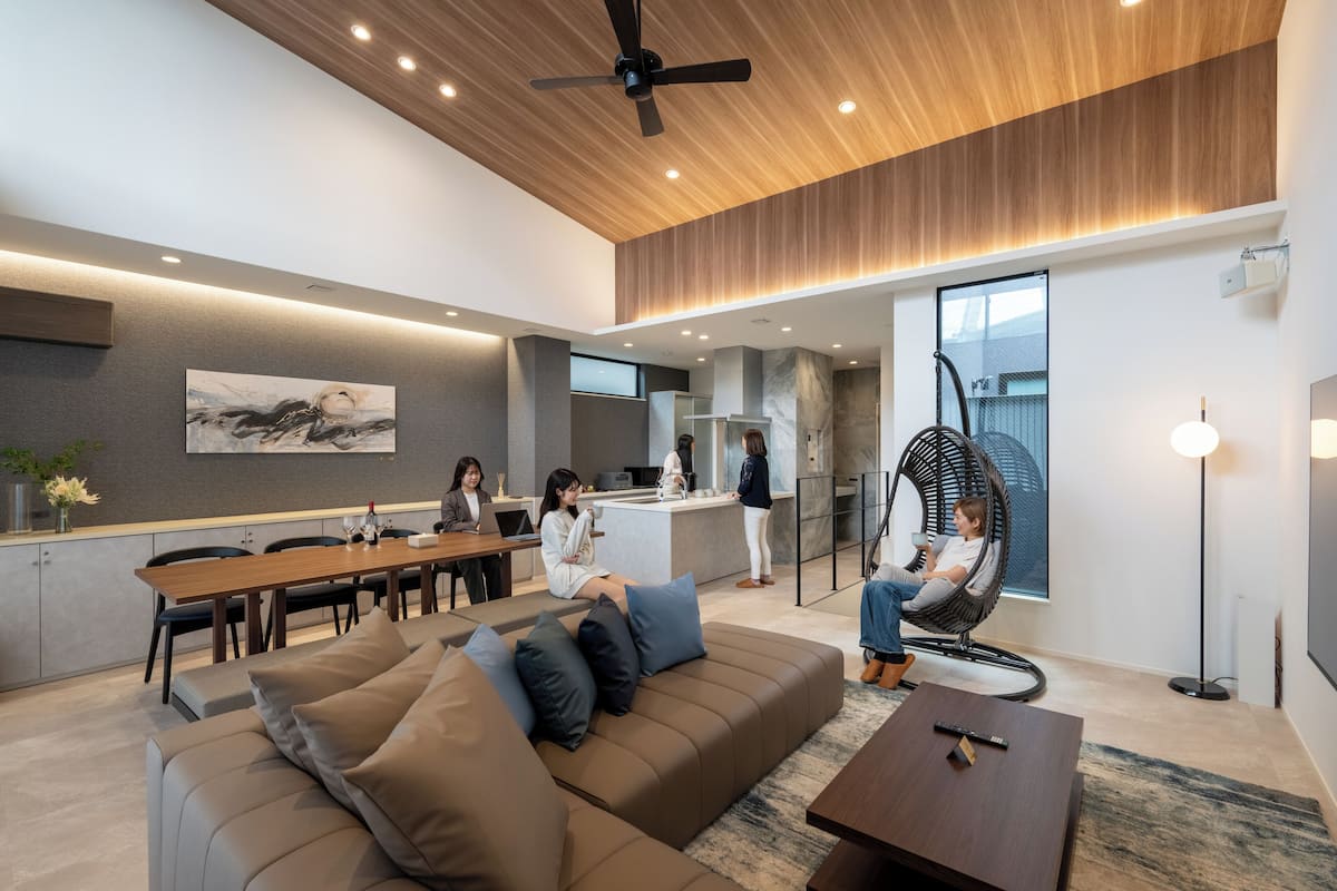 A modern living room with a sofa, a coffee table, and a dining area with a table and chairs.