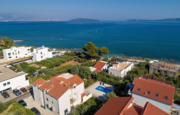 Un quartier résidentiel en bord de mer, avec des immeubles modernes, une piscine et une vue sur la mer.