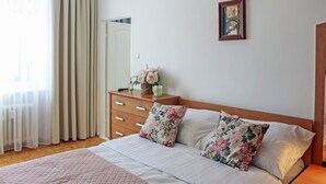 A neatly arranged bedroom with a bed, a dresser, a nightstand, and a painting on the wall. - Nice apartment in Koszalin with WiFi (Koszalin)