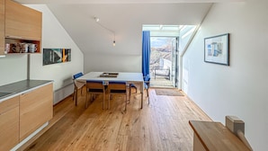 Een moderne keuken met houten kastjes en een eethoek met een tafel en stoelen.