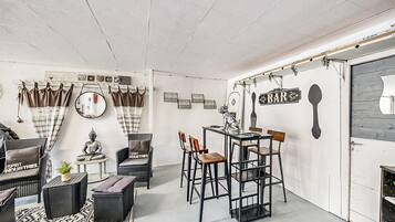 Une pièce chaleureuse comprenant un coin repas, un canapé, une petite table avec une plante et une statue.