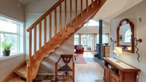 A staircase leading to a living area with a fireplace, a sofa, and a lamp.