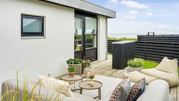 A modern outdoor patio with a sofa, tables, and potted plants. - Awesome home in Juelsminde with WiFi (Juelsminde)