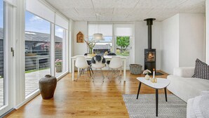 A spacious living room with a large window, a fireplace, a dining area, and a cozy seating area. - Awesome home in Juelsminde with WiFi (Juelsminde)