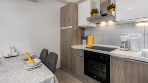 A modern kitchen with a built-in oven, a coffee maker, and a sink. - Cozy apartment in Dramalj with house sea view (Dramalj)