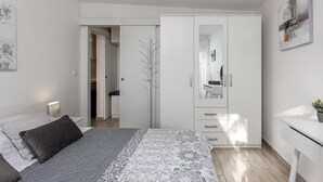 A bedroom with a bed, a wardrobe, a desk, and a mirror. - Cozy apartment in Dramalj with house sea view (Dramalj)