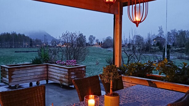 Un espace extérieur aménagé avec une table, des chaises, une bougie et une lanterne.