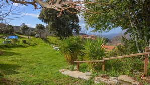 A lush garden with a wooden staircase leading up to a deck, surrounded by greenery and a view of distant hills. - 2 bedroom nice (sta)caravan in CASALABRIVA (CASALABRIVA)