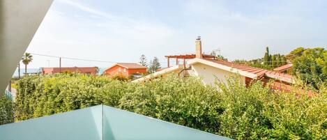 Vista de una zona residencial con casas, cielo despejado y abundante vegetación.