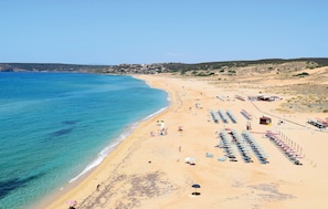 A beach with rows of sunbeds and umbrellas, a lifeguard tower, and a clear view of the sea. - Stunning home in Torre dei Corsari (Torre dei Corsari)