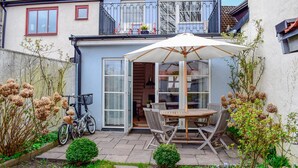 A patio with a table and chairs, a bicycle, and a small garden. - 2 bedroom lovely home in Ystad (Ystad)