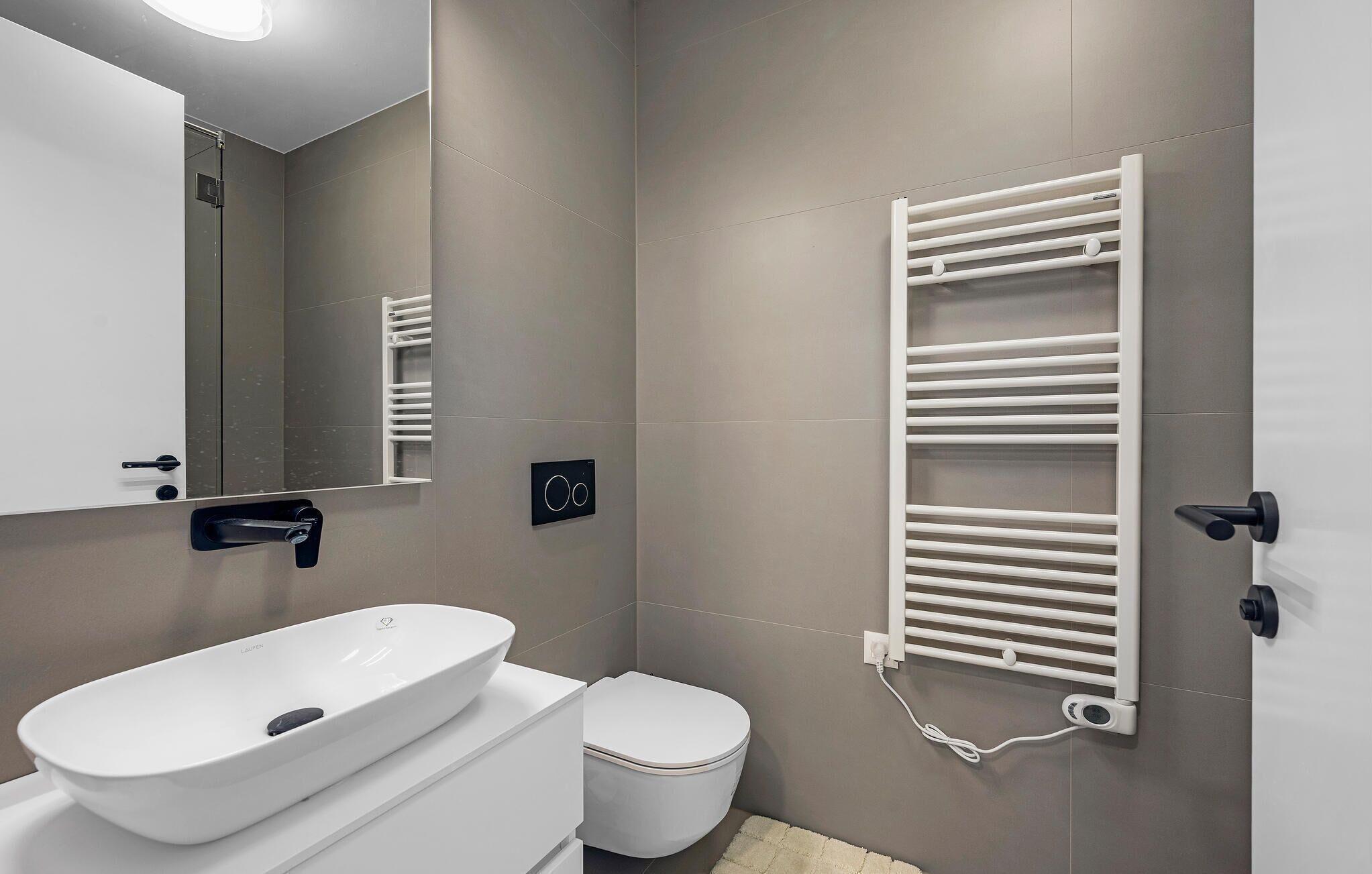 Ein modernes Badezimmer mit Waschbecken, Toilette und Handtuchhalter.