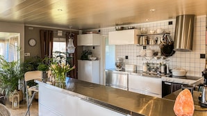 A modern kitchen with white cabinets, a stainless steel island, and a gas stove.