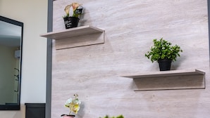 A wall with three wooden shelves, each holding a potted plant. - Venue 360 (Freetown)
