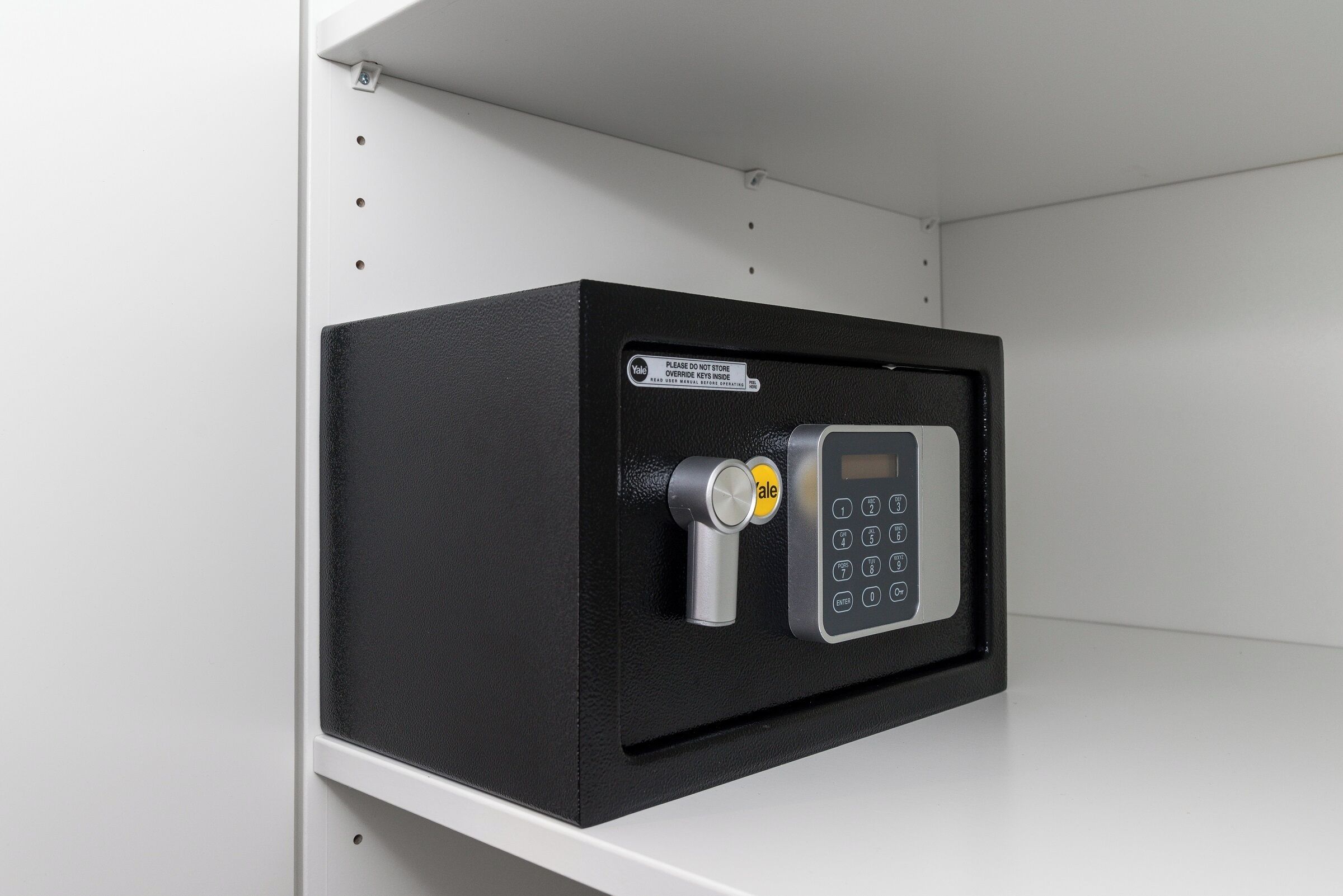 A secure storage box with a keypad lock and a warning label.