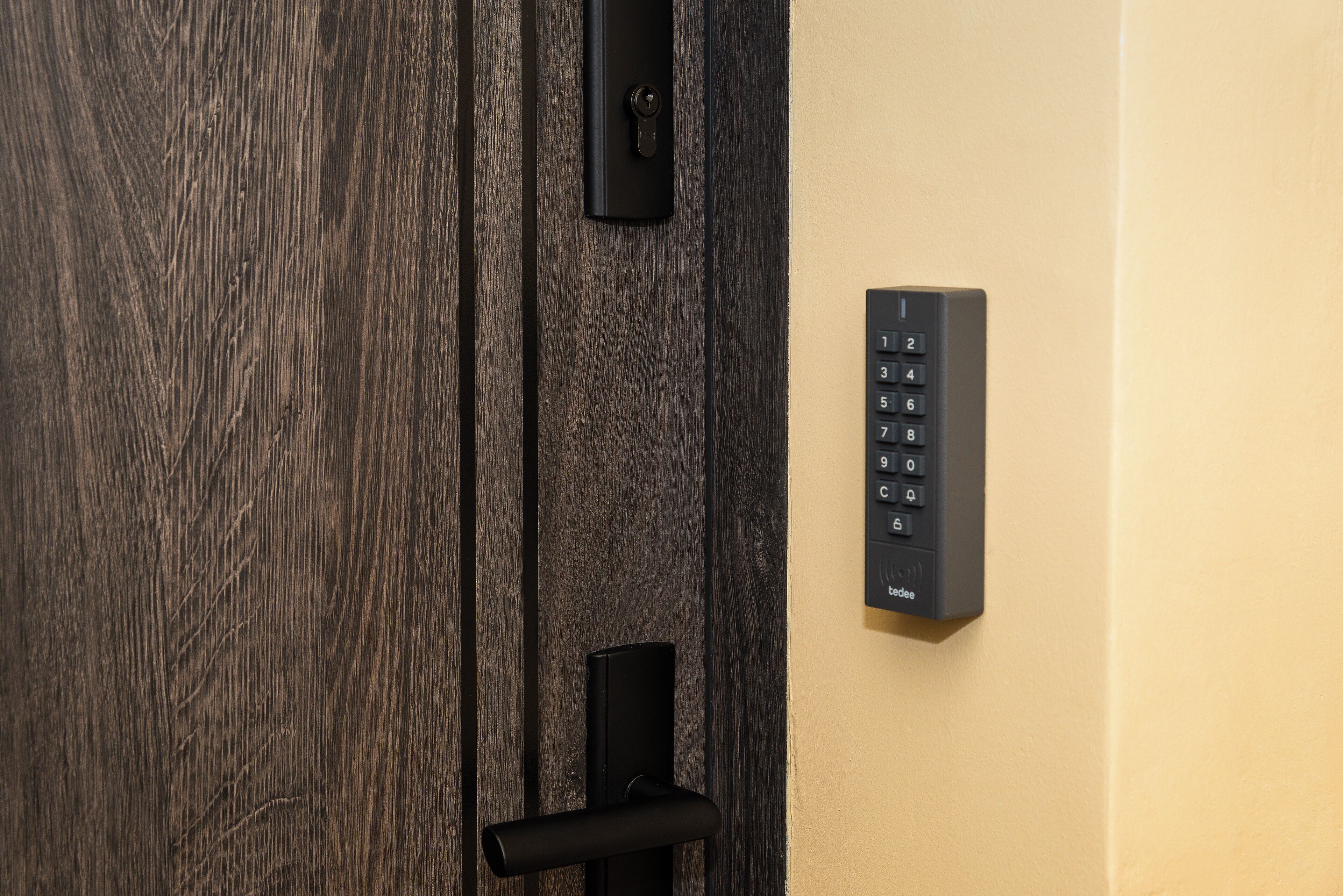 Una puerta de madera con un ojo de cerradura y una cerradura electrónica moderna.