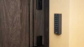 Una puerta de madera con un ojo de cerradura y una cerradura electrónica moderna.