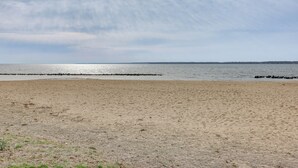 Een strand met een zandstrand en een rustige zee.