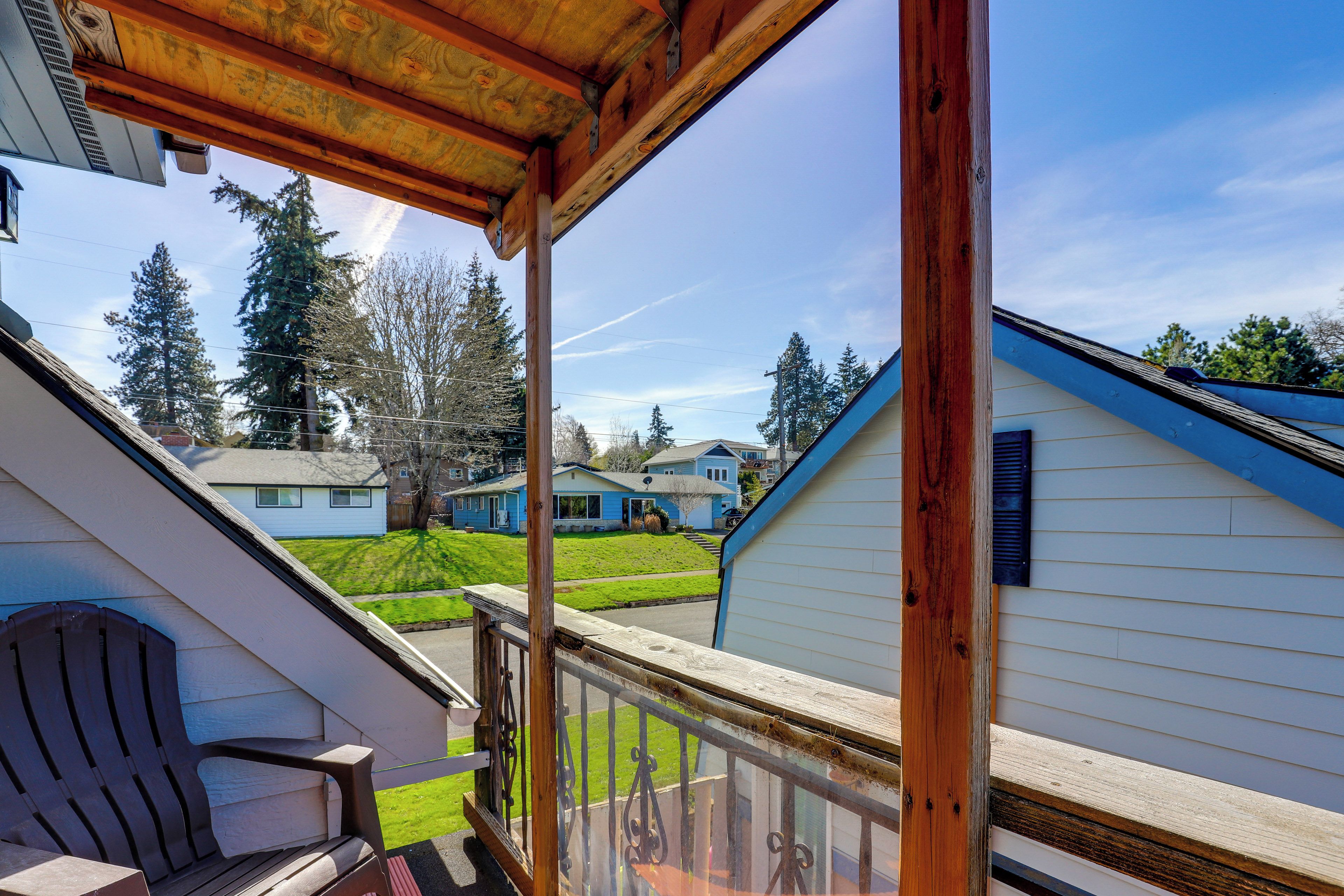 A wooden deck with a view of neighboring houses and a lawn.
