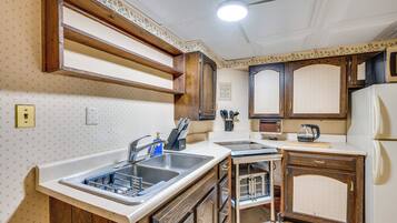 A kitchen with wooden cabinets, a sink, and a refrigerator.