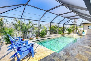 An indoor swimming pool with clear water, surrounded by blue lounge chairs and potted plants. - Beautiful Venice Getaway, 4 Mi to Manasota Beach! (Venice)