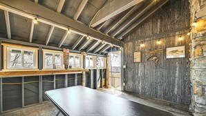 A room with a long table, wooden beams, stone walls, and framed pictures. - Water-view Deck: Home on Dale Hollow Lake (Albany)