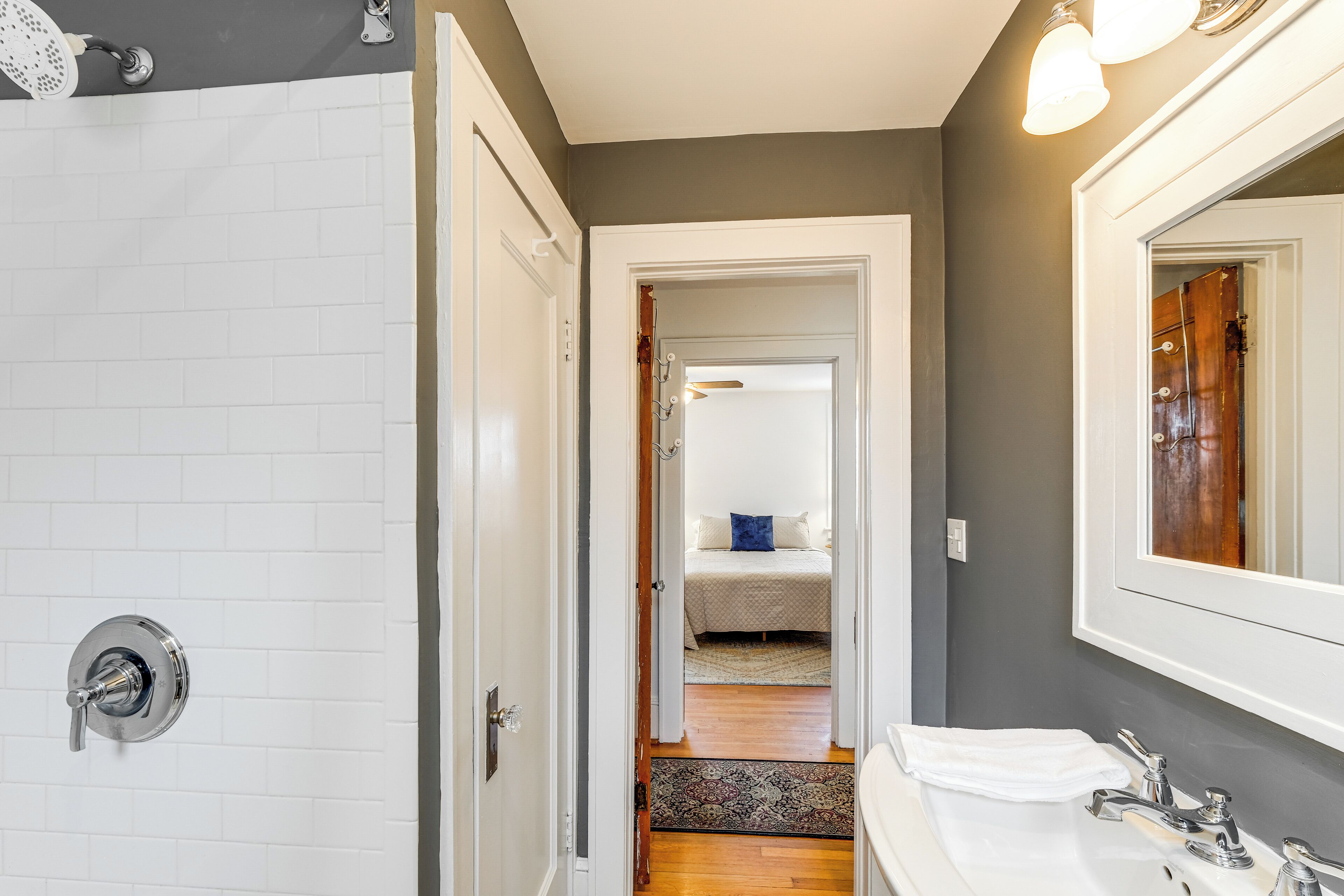 A bathroom with a shower, sink, and mirror.