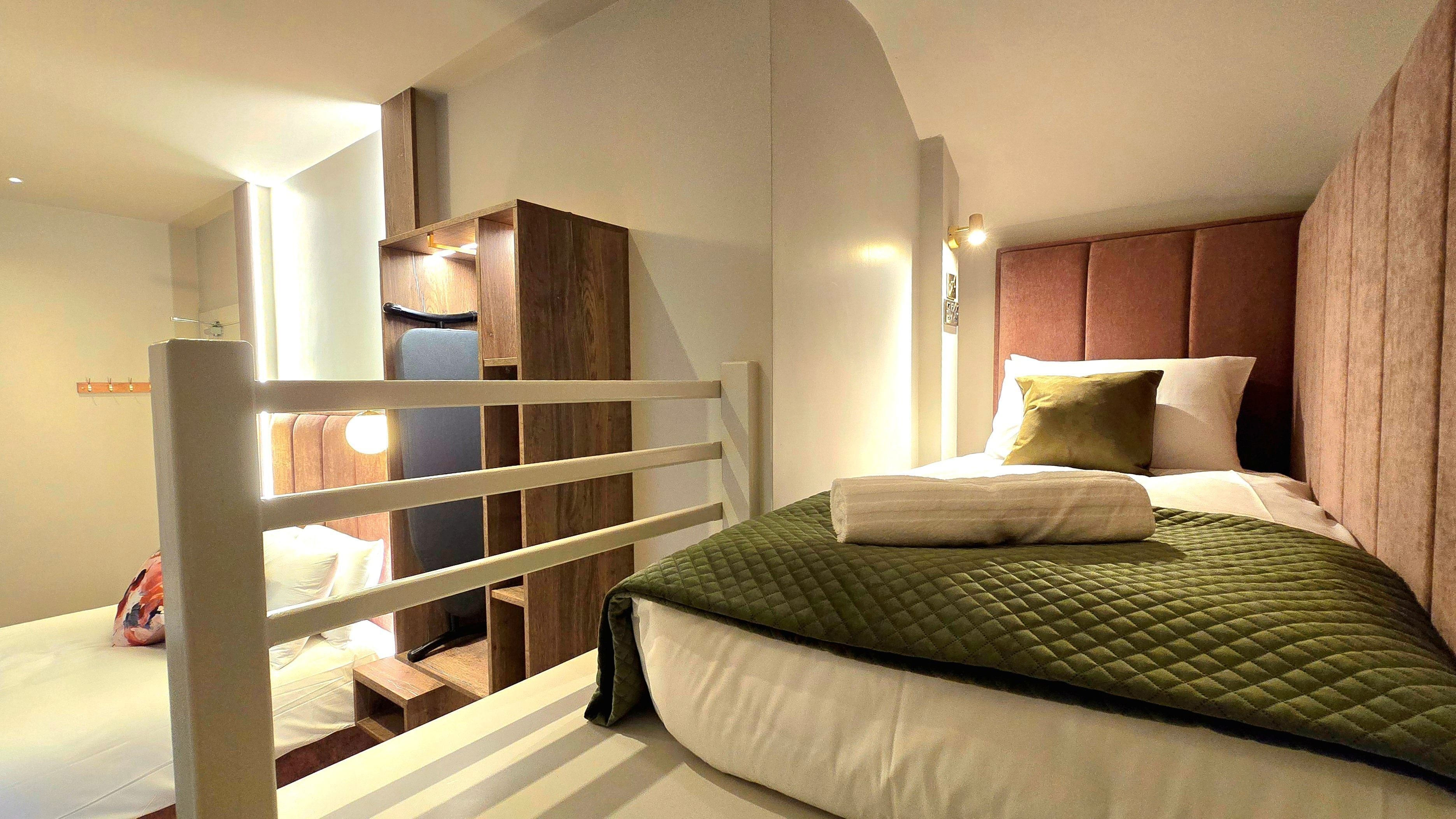 A bedroom with a bed, a wardrobe, and a chair.