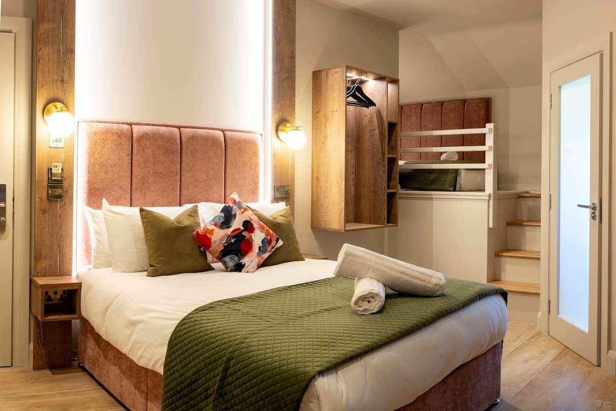Ein ordentlich eingerichtetes Schlafzimmer mit einem großen Bett, einem Holzschrank und einer kleinen Regalwand.