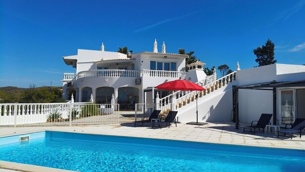 A large, white, two-story house with a swimming pool in the foreground. - Casa da Amizade - Tavira (Horta)
