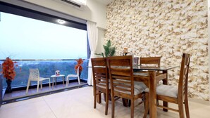 Un comedor con balcón, papel tapiz floral y vistas de la ciudad.