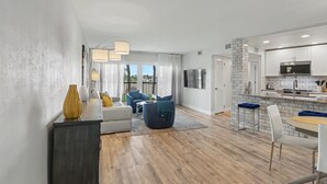 A modern apartment with a living room, dining area, and kitchen. - 🏖️Beachfront Community🌴Land's End 1-206☀Heated Pool/Hot Tub🐬Bay Views (Treasure Island)