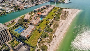 An aerial view of a coastal residential area with a marina, a tennis court, and a beach. - 🏖️Beachfront Community🌴Land's End 1-206☀Heated Pool/Hot Tub🐬Bay Views (Treasure Island)