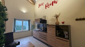 Une cuisine chaleureuse avec une pancarte indiquant « Espace d’amour », des armoires en bois, une table à manger et une fenêtre donnant sur un beau paysage.
