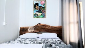 A bed with a wooden headboard, white pillows, and a patterned bedspread. - ENTRE VALLEE (Rodrigues Island)