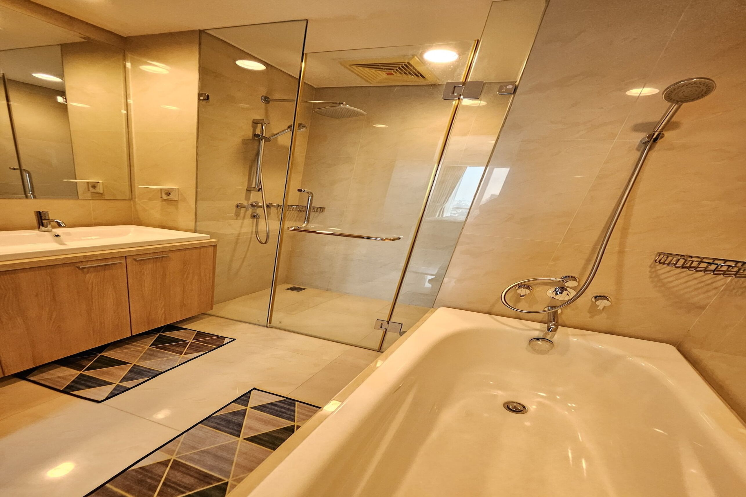 Une salle de bain moderne dotée d’une douche à parois de verre, d’une baignoire et d’un meuble-lavabo avec un miroir.