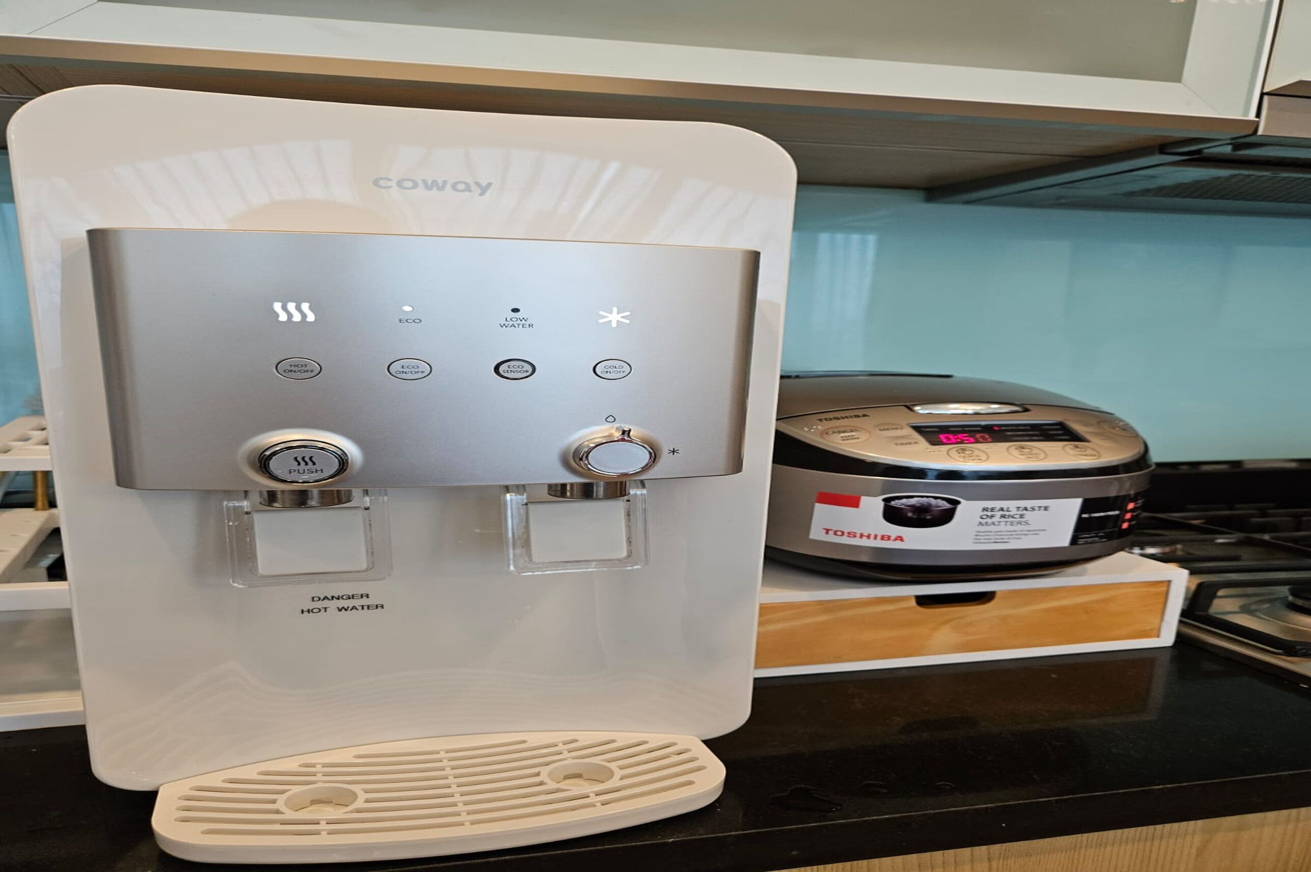 Una máquina de café con varios botones y un depósito de agua sobre una encimera de cocina.