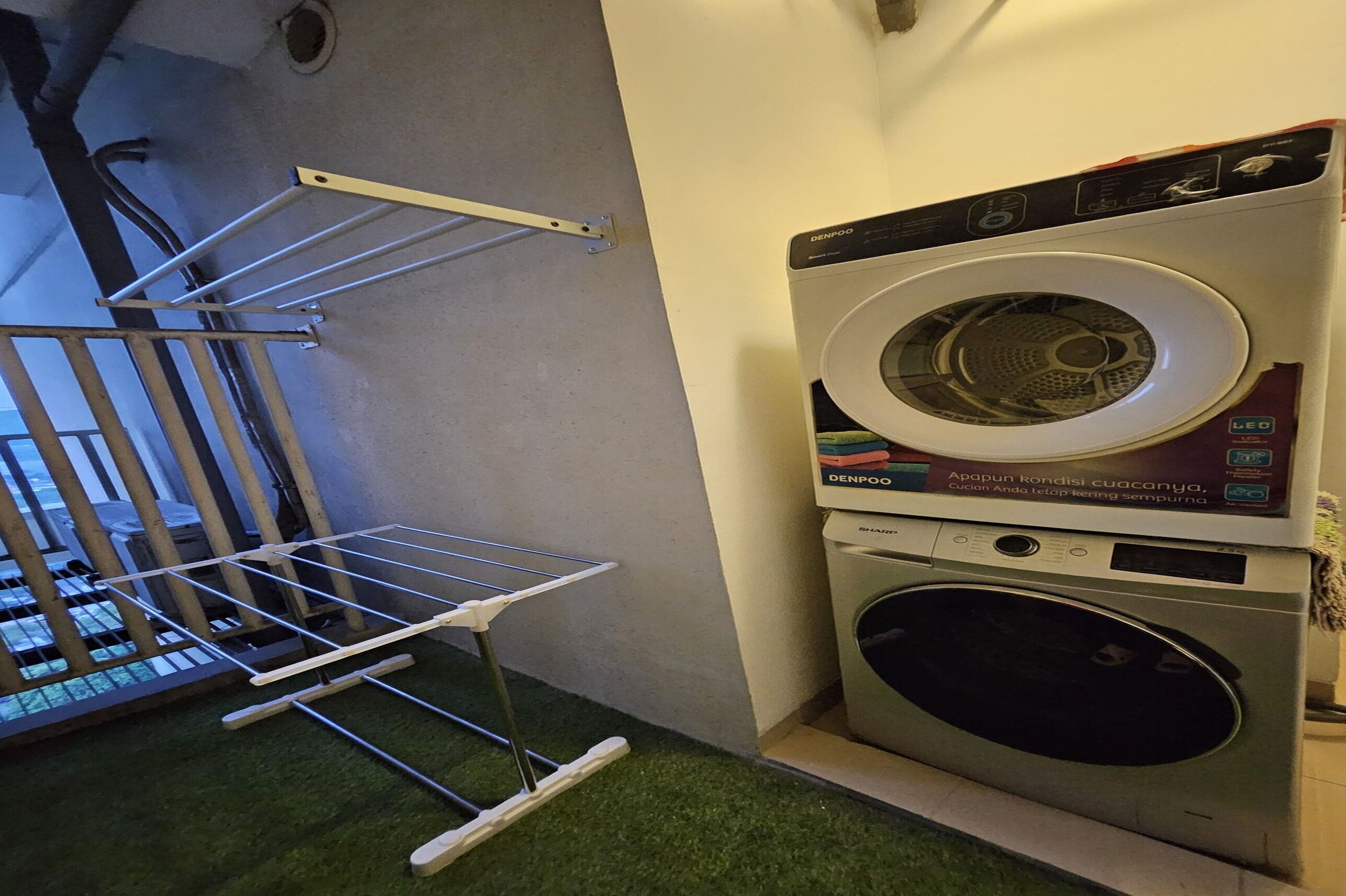 Un espace buanderie équipé d’un lave-linge et d’un étendoir.