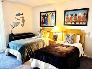 A hotel room with two beds, a nightstand with a lamp, and artwork on the walls. - Island Reef #501 Beachfront Condo (Fort Myers Beach)