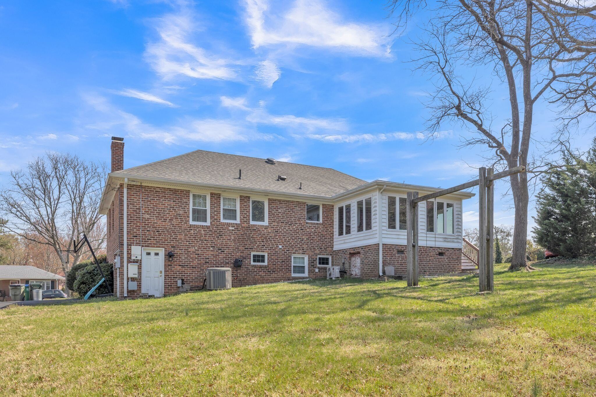 A two-story brick house with a covered porch and a small attached garage.