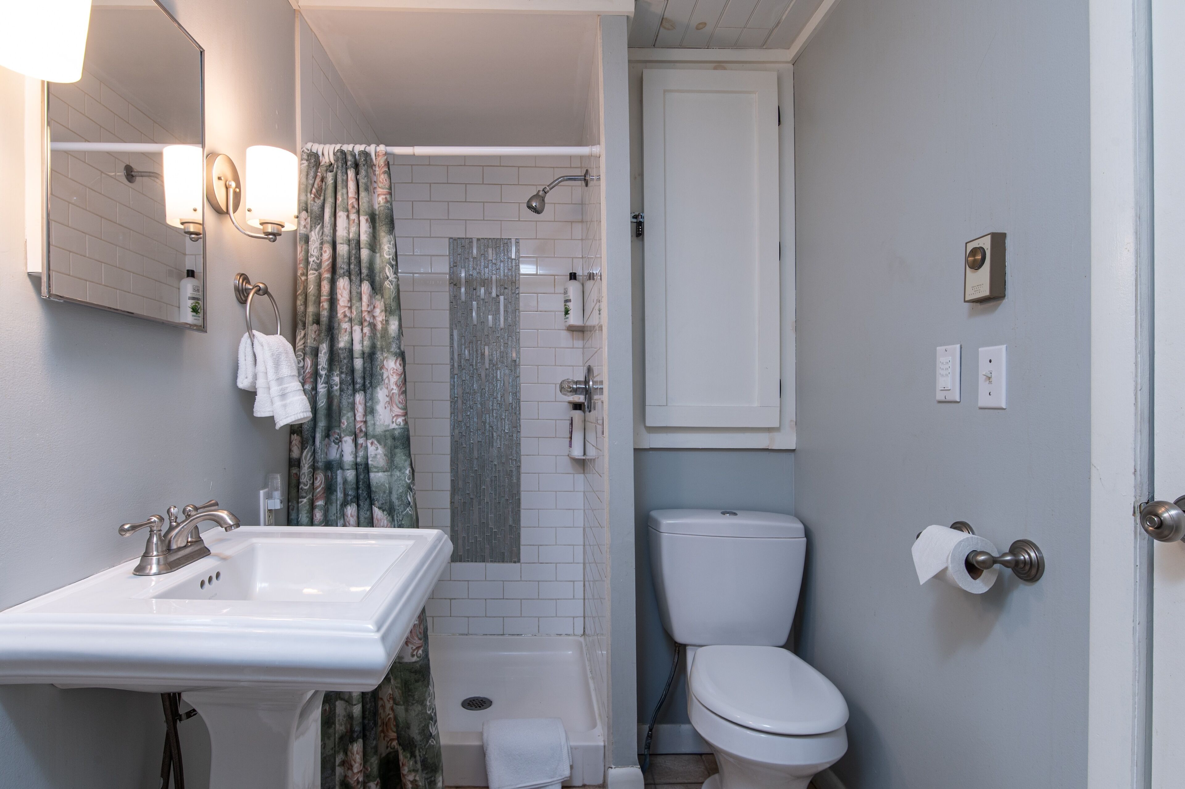 Une salle de bain équipée d’un lavabo, de toilettes, d’une douche et d’une porte à serrure.