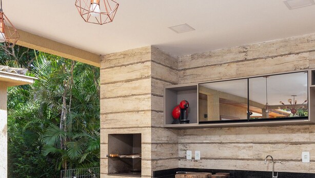 A modern kitchen with a built-in stove, a sink, and a wooden backsplash. - Bz40 Casa 180m praia piscina privativa (Buzios)