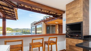 A bar area with wooden chairs and a grill. - Bz40 Casa 180m praia piscina privativa (Buzios)