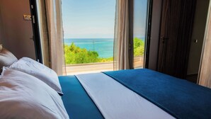 Un dormitorio con cama, vistas al mar y un balcón.