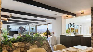Un comedor moderno con pared de piedra, ventanas amplias y vista a la ciudad.
